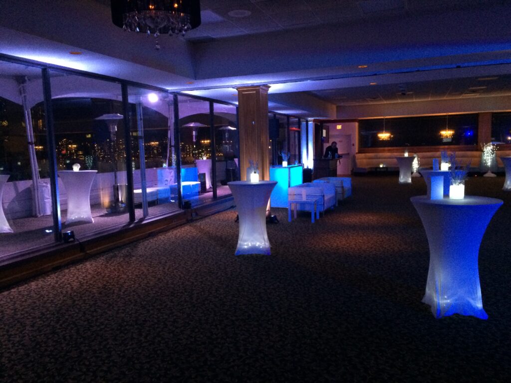 Blue LED uplighting in Vancouver event venue during cocktail reception with illuminated tables.